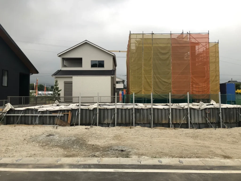 道路側から見た基礎型枠と隣接する建物の足場