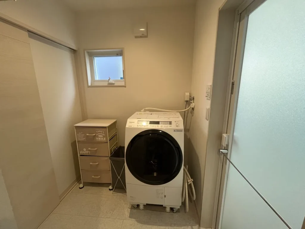 ドラム式洗濯乾燥機と収納ワゴンを置いた脱衣室