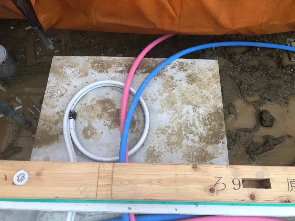 建物下部に通された青・赤・白の配管用樹脂管