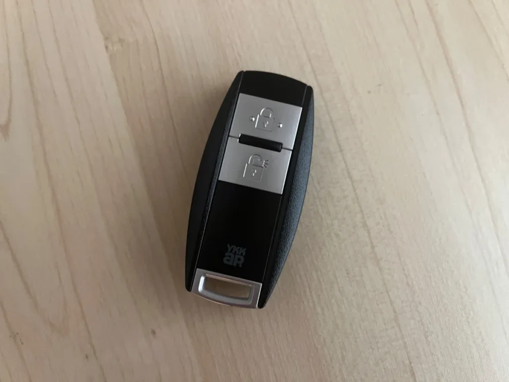木目のテーブルに置かれたYKK APのスマートキーリモコン