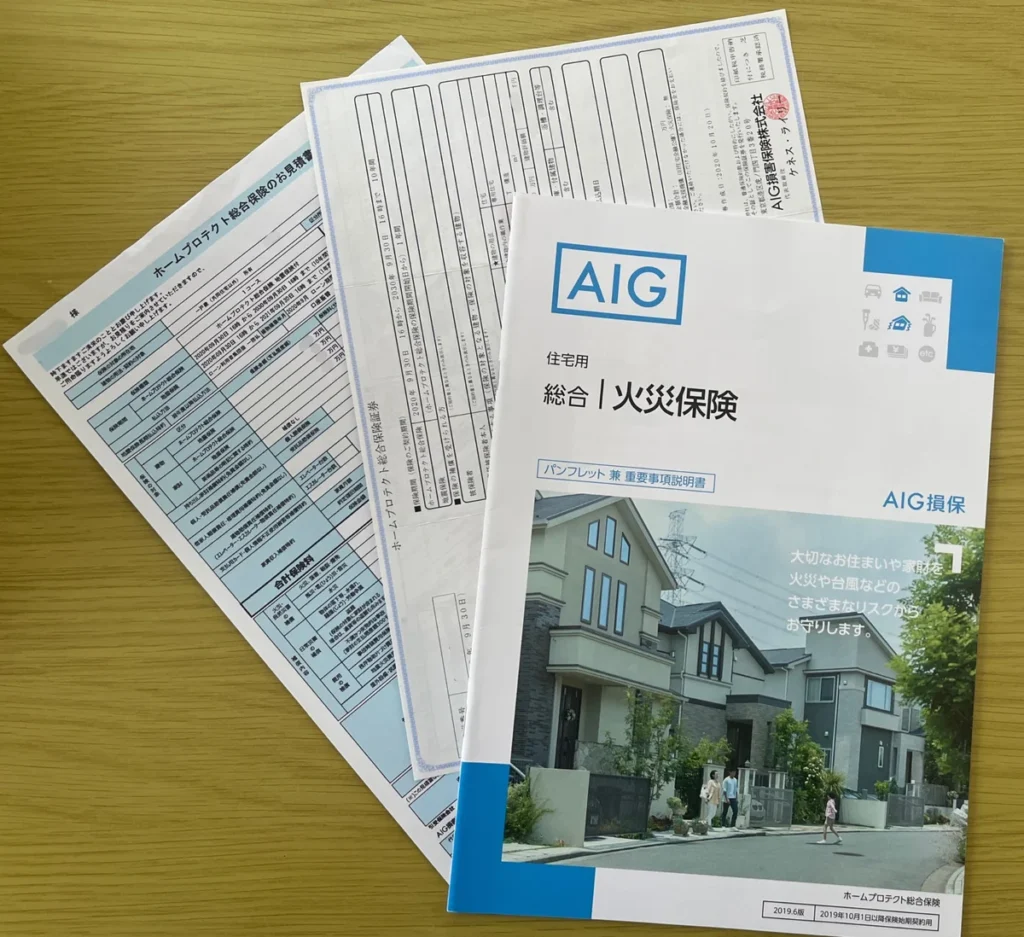 AIG損保の住宅用総合火災保険パンフレットと見積書、保険証券を机上に並べた写真