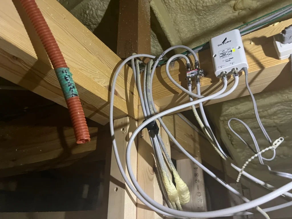 屋根裏に設置されたブースター用電源と複数の同軸ケーブル配線