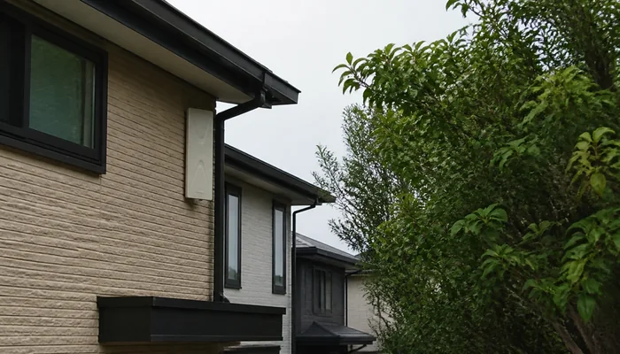 住宅の外壁付近で樹木に遮られたデザインアンテナの設置環境