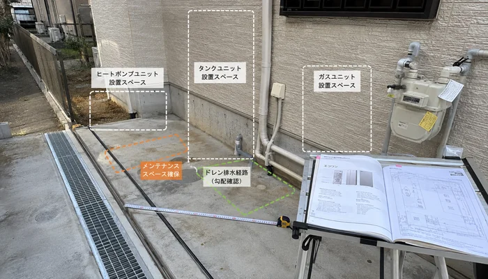 住宅外壁まわりでヒートポンプやタンクの設置スペース、排水経路を確認するイメージ