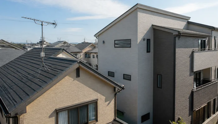 近接する高い住宅と手前の戸建て屋根に立つテレビアンテナ