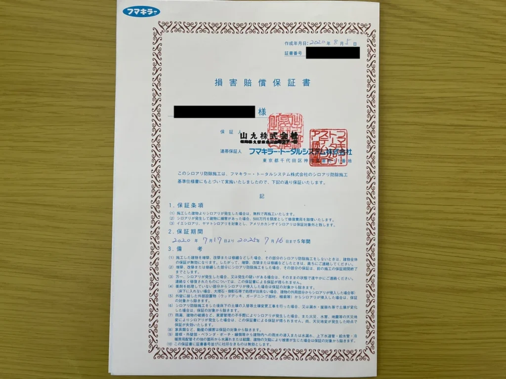 シロアリ防除施工の損害賠償保証書。保証条項、保証期間5年間、備考が記載されている。