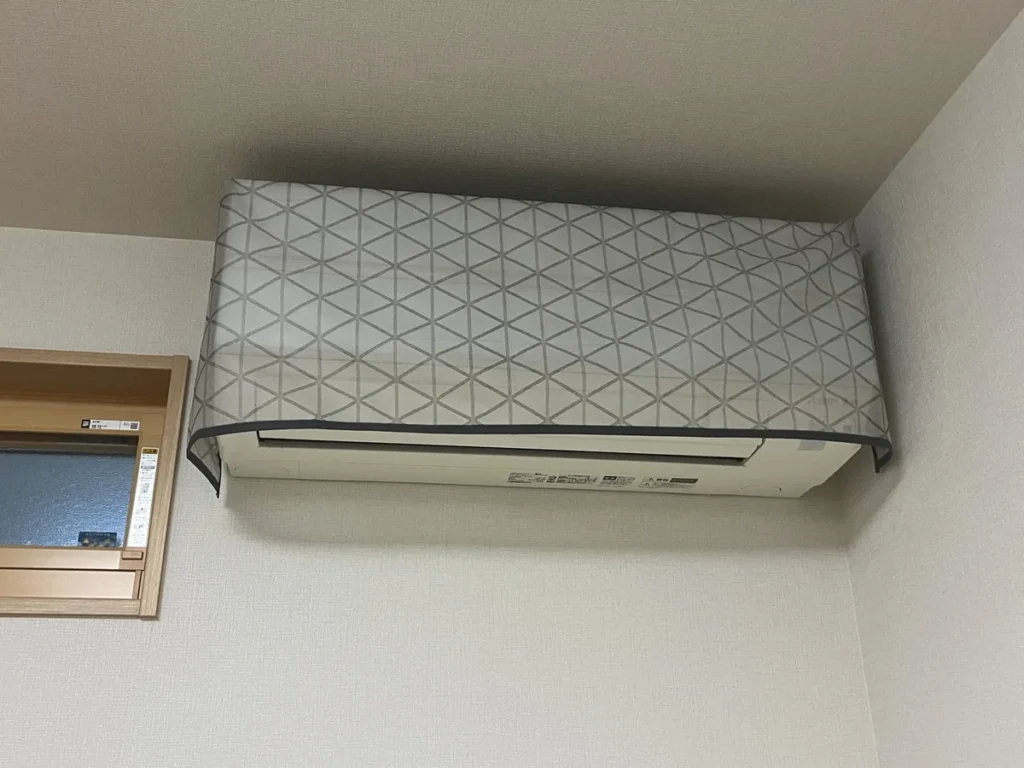 エアコン室内機の上部と前面を覆う布製カバー