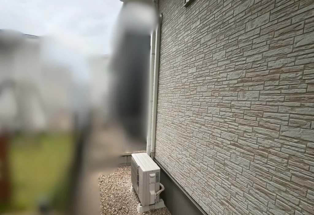 住宅の側面通路に設置されたエアコン室外機