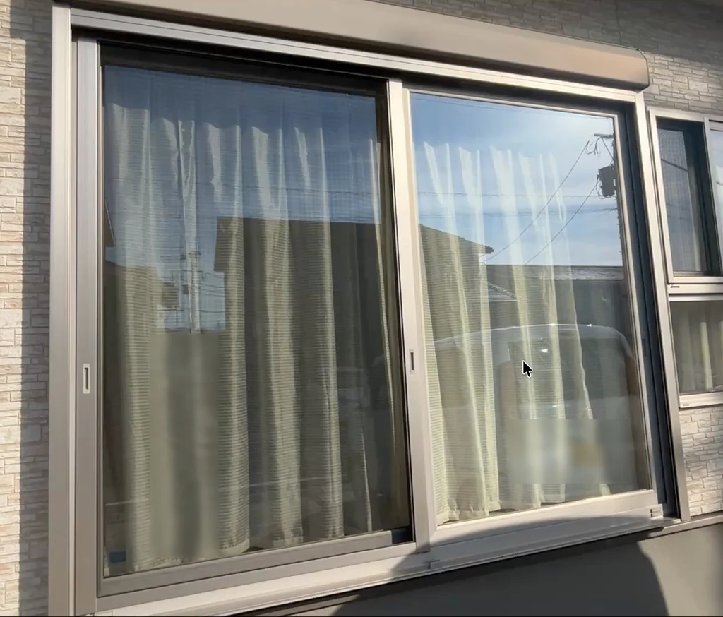 屋外から正面方向に見た大きな2枚建て引き違い窓。上にシャッターボックスが付いている